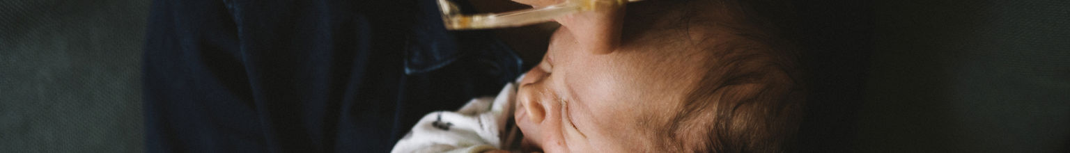 Mamma pussar sin nyfödda bebis på pannan