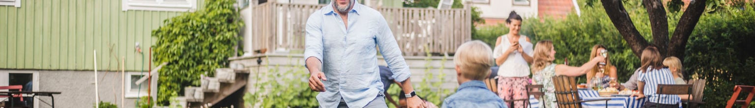 Pappa och pojke spelar fotboll på tomten utanför ett hus