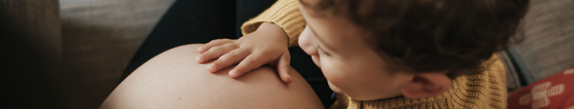 Pojke klappar på sin mammas mage