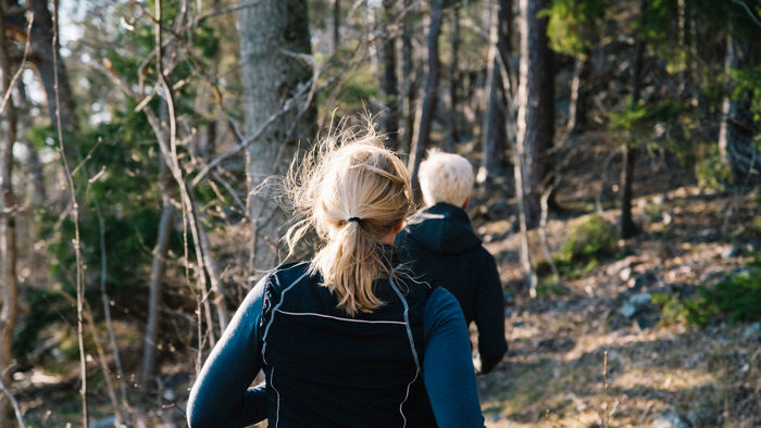 Två personer som joggar i skogen.